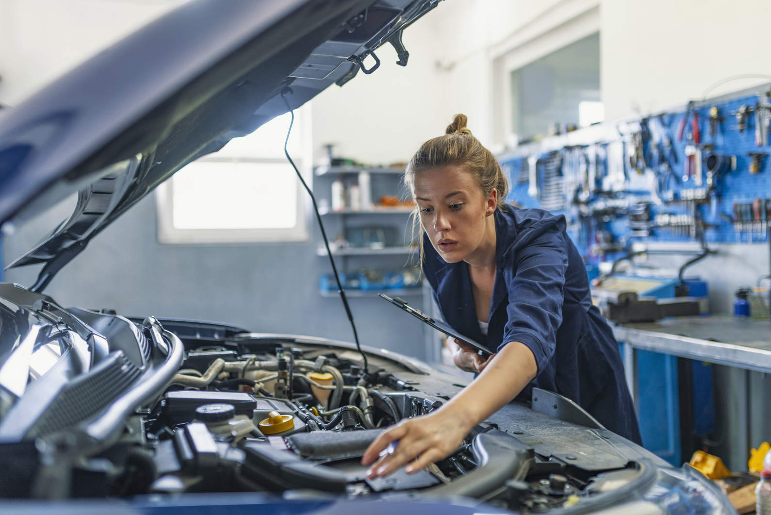 Mechanic working under the hood at the repair garage