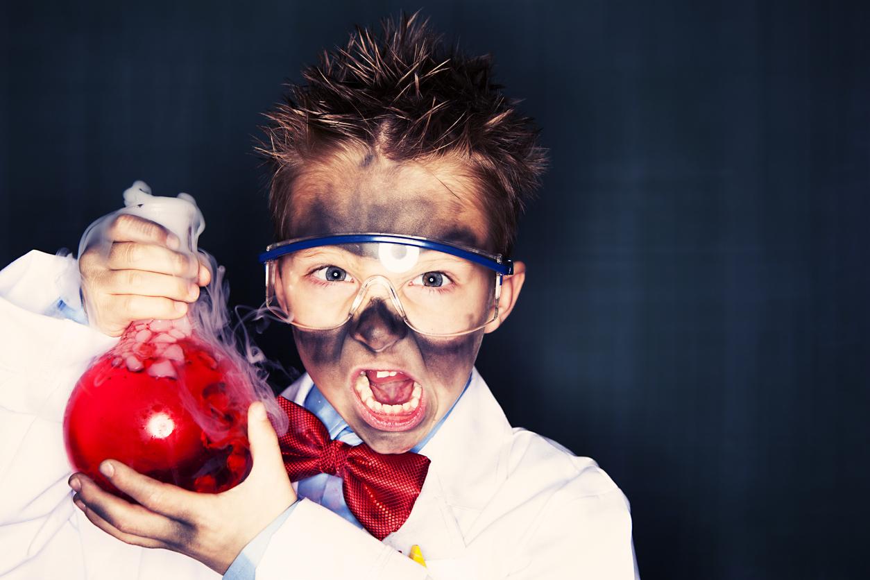 Young mad scientist holding bomb